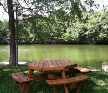 Quality Patio Furniture Octagon Picnic Table with Attached Benches - seats 8 adults Handcrafted by Jack Hudson (830) 367-3848 Octagon Picnic Table with Attached Benches set in a grassy riverbank by a beautiful green river Quality Patio Furniture Handcrafted by Jack Hudson (830) 367-3848
